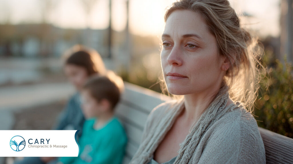 Woman sitting on a bench with her children while experiencing whiplash.